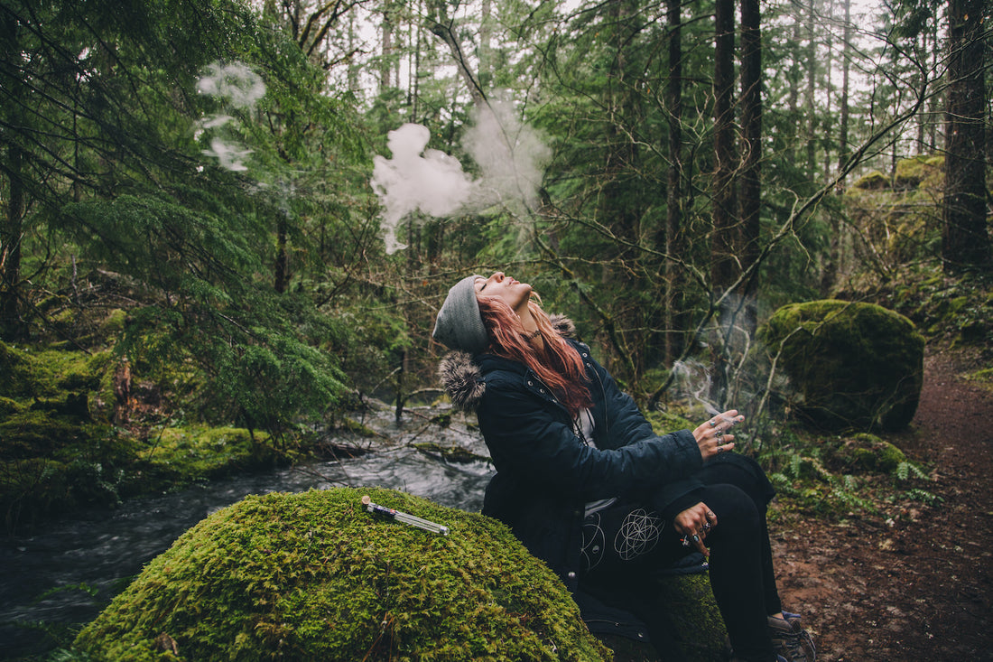 Woman smoking cannabis being zen in the woods